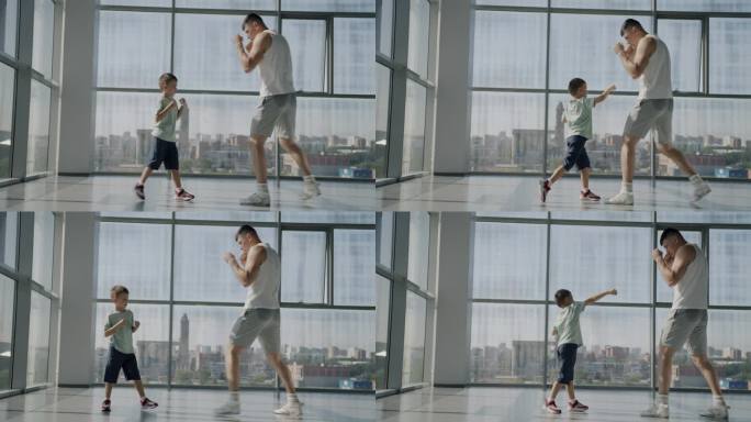 可爱的小男孩在健身房和爸爸一起练习拳击，享受家庭锻炼