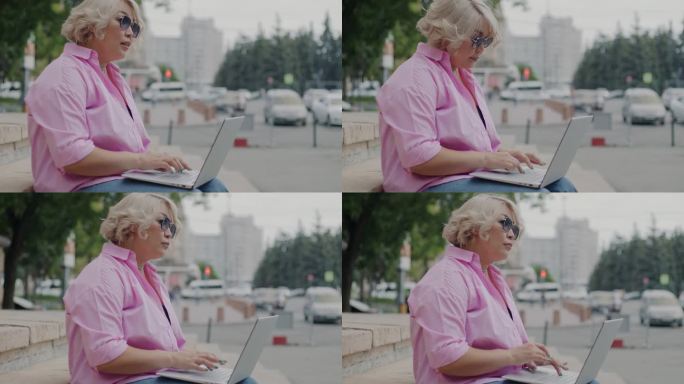 年轻的女士自由职业者使用笔记本电脑在外面忙着交流坐在城市街道