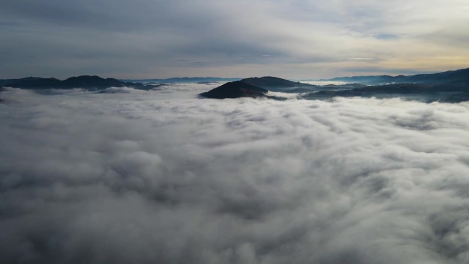 飞过山顶的云层。山峰高耸，清晨日出，自然景观优美