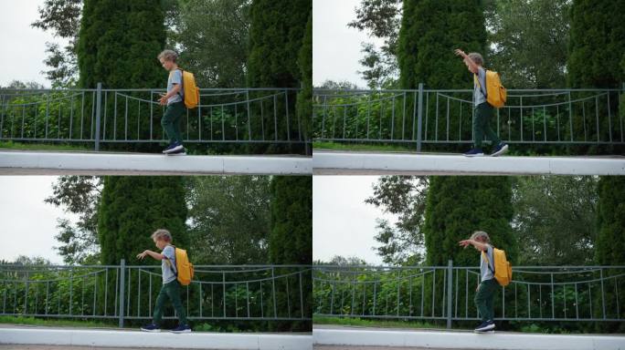 可爱的小男孩背着背包走在公园的路边，回家或上学