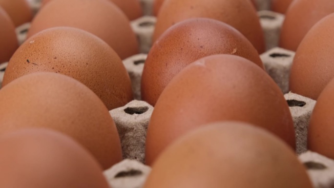 鸡蛋盒里的生鸡蛋凑近。鸡蛋在面板里。厨房里装着新鲜鸡蛋的纸箱。
