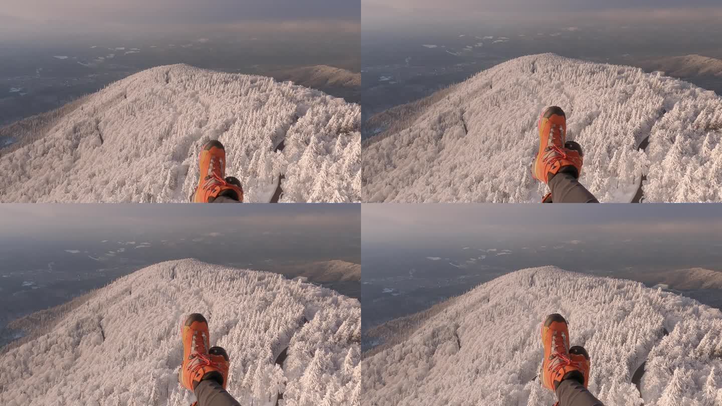 POV滑翔伞向下看雪景，在框架的底部看到脚