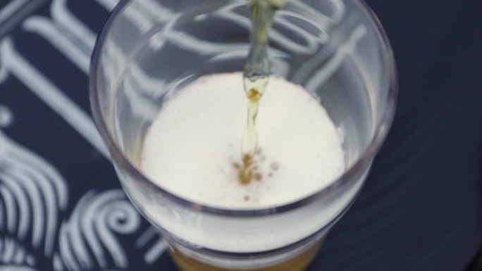 啤酒源源不断地涌进满是泡沫的杯子里