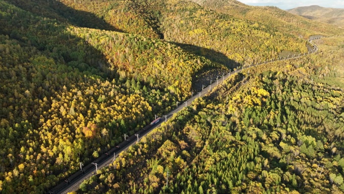 大兴安岭林海间行驶的铁路煤炭运输列车