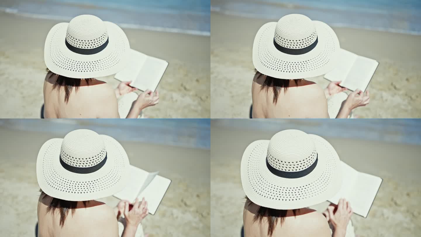 中年西班牙女游客晒日光浴，坐在沙滩上看书