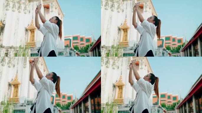年轻的亚洲女子惊叹于曼谷美丽的寺庙，并拍下了照片。