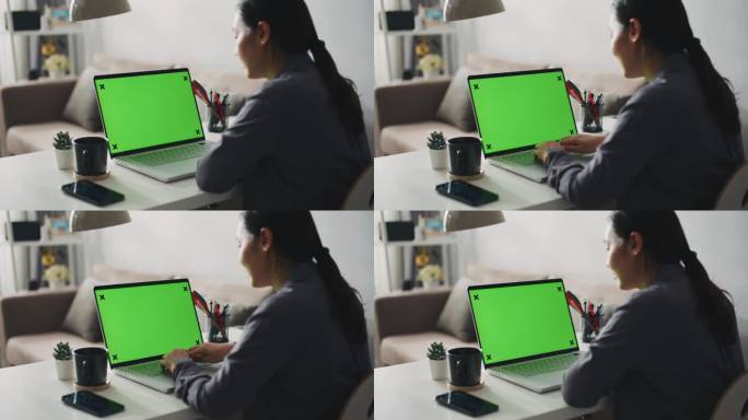 妇女在家里使用绿屏笔记本电脑