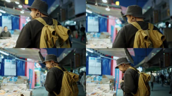 一名亚洲男子走过东京的食品市场，环顾四周的食品。