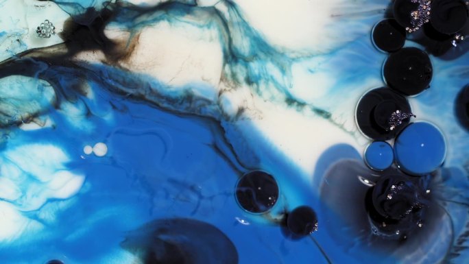 抽象艺术背景的蓝色和黑色的油漆泡沫破裂和漩涡