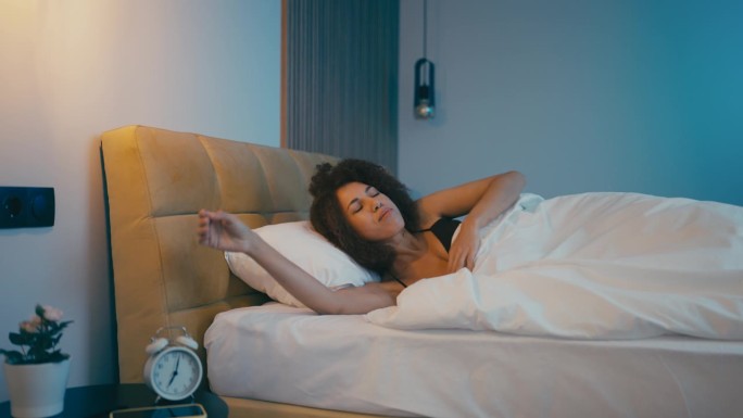 年轻的非裔美国女性在高质量的睡眠后醒来，早上的例行公事