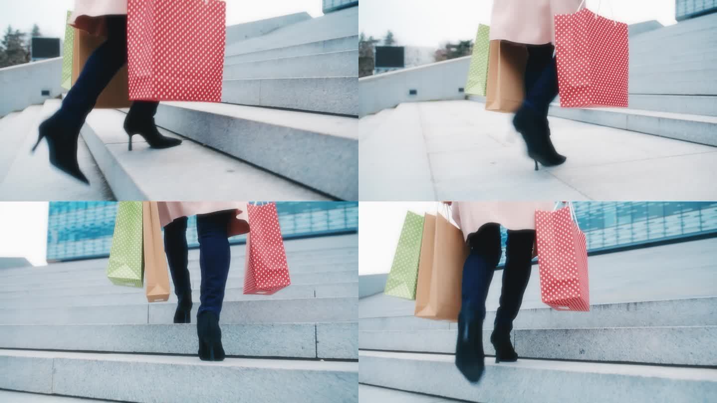 一个难以辨认的穿着高跟鞋的女人拎着购物袋走在一座现代建筑前的楼梯上