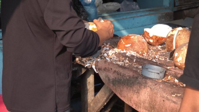 水果商人剥去椰子的皮并清洗干净。传统市场商店里商人的气氛