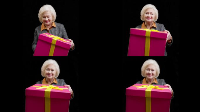 开朗的资深女士拿出巨大的粉色礼盒，生日祝福，惊喜