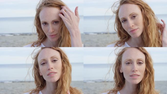 美丽的年轻女子在热带海滩上用手穿过风吹过的头发的特写镜头