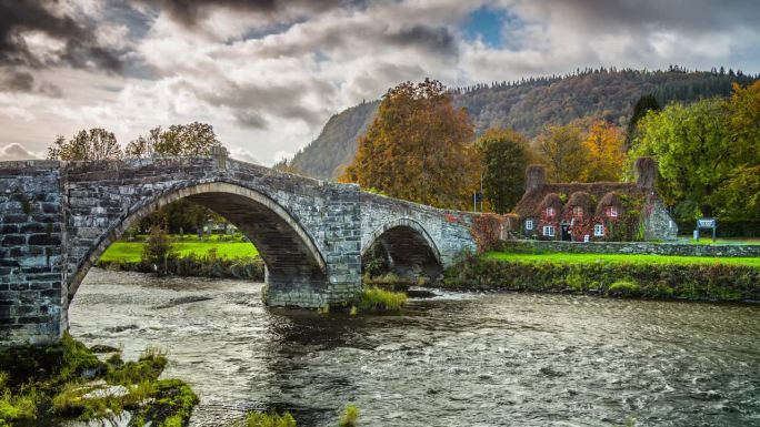 田园诗般的风景，古老的石桥和覆盖着藤蔓叶子的小屋，北威尔士卡那封的Llanrwst