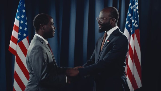 黑人男性政治家和同事在闪光灯前握手