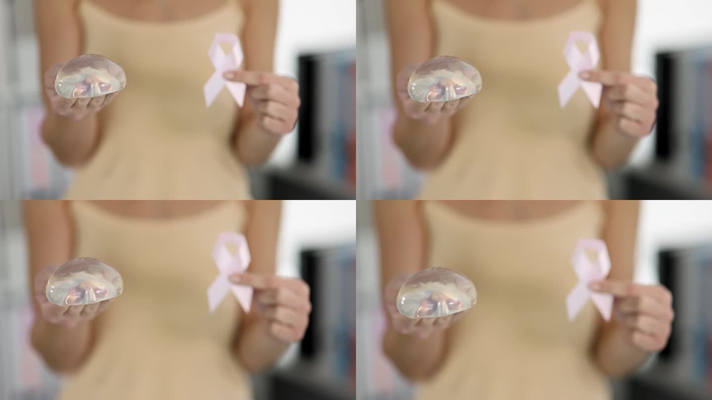 诊所4k电影里拿着硅胶隆胸假体和粉色丝带的女人