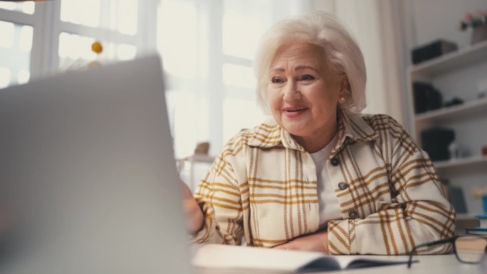 老年女性在家接受在线课程，在老年时开始新的职业生涯
