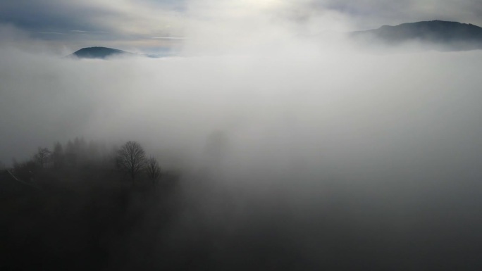 飞过山顶的云层。山峰高耸，清晨日出，自然景观优美