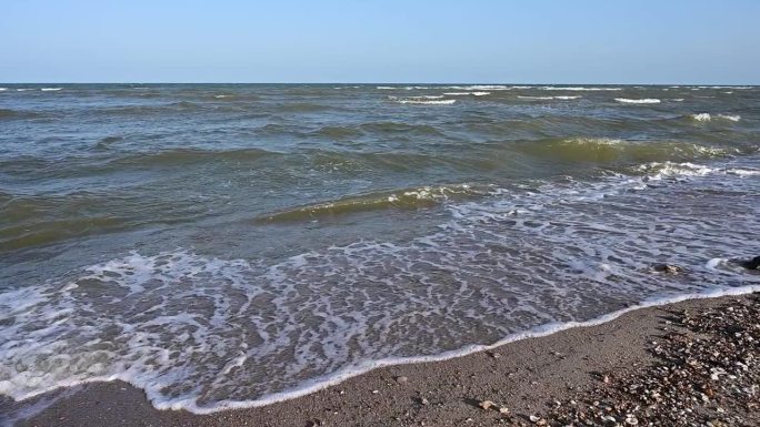 慢动作水波在大海和沙滩景观与蓝天，美丽的自然背景