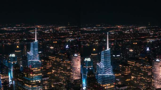 垂直屏幕:办公楼夜间航拍画面。房间里亮着灯，在纽约工作的商人和经理。直升机俯瞰曼哈顿的夜景