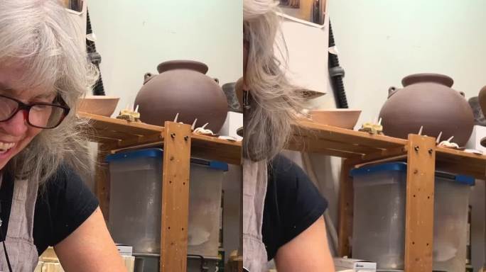 美丽的灰发成年女子粘土雕塑她做了一个makitra向右转拿了另一个工具，可以从产品上切下多余的粘土她