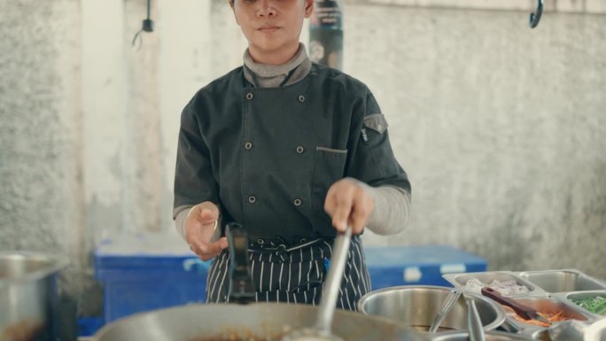 亚洲女厨师烹饪美味的传统泰式炒面在曼谷街头市场厨房-泰国街头食品。