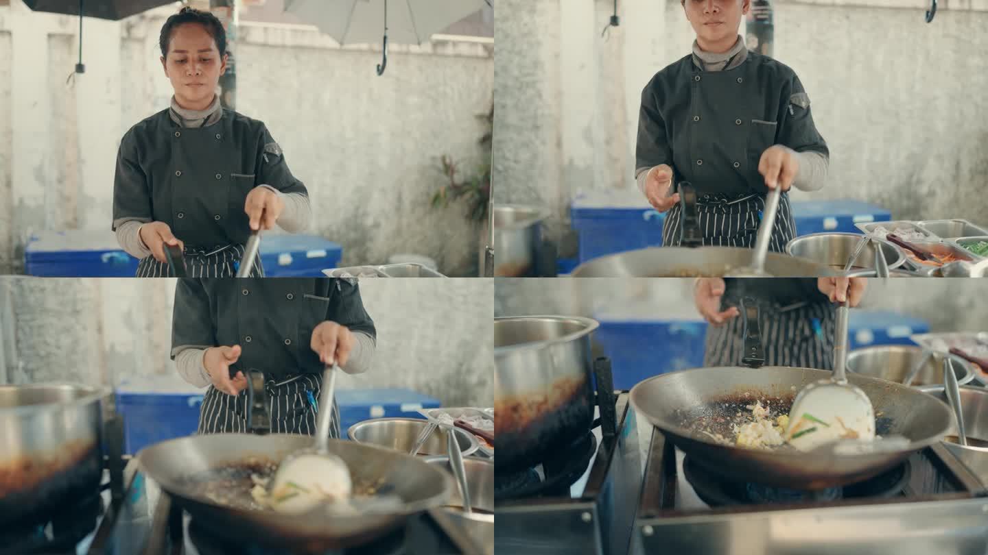 亚洲女厨师烹饪美味的传统泰式炒面在曼谷街头市场厨房-泰国街头食品。