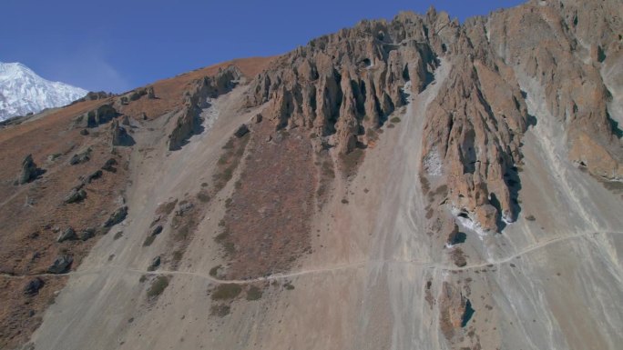 空中鸟瞰四名徒步旅行者一起跋涉到喜马拉雅山的提利科大本营。徒步探险，旅行团在导游的带领下安全地走在尼