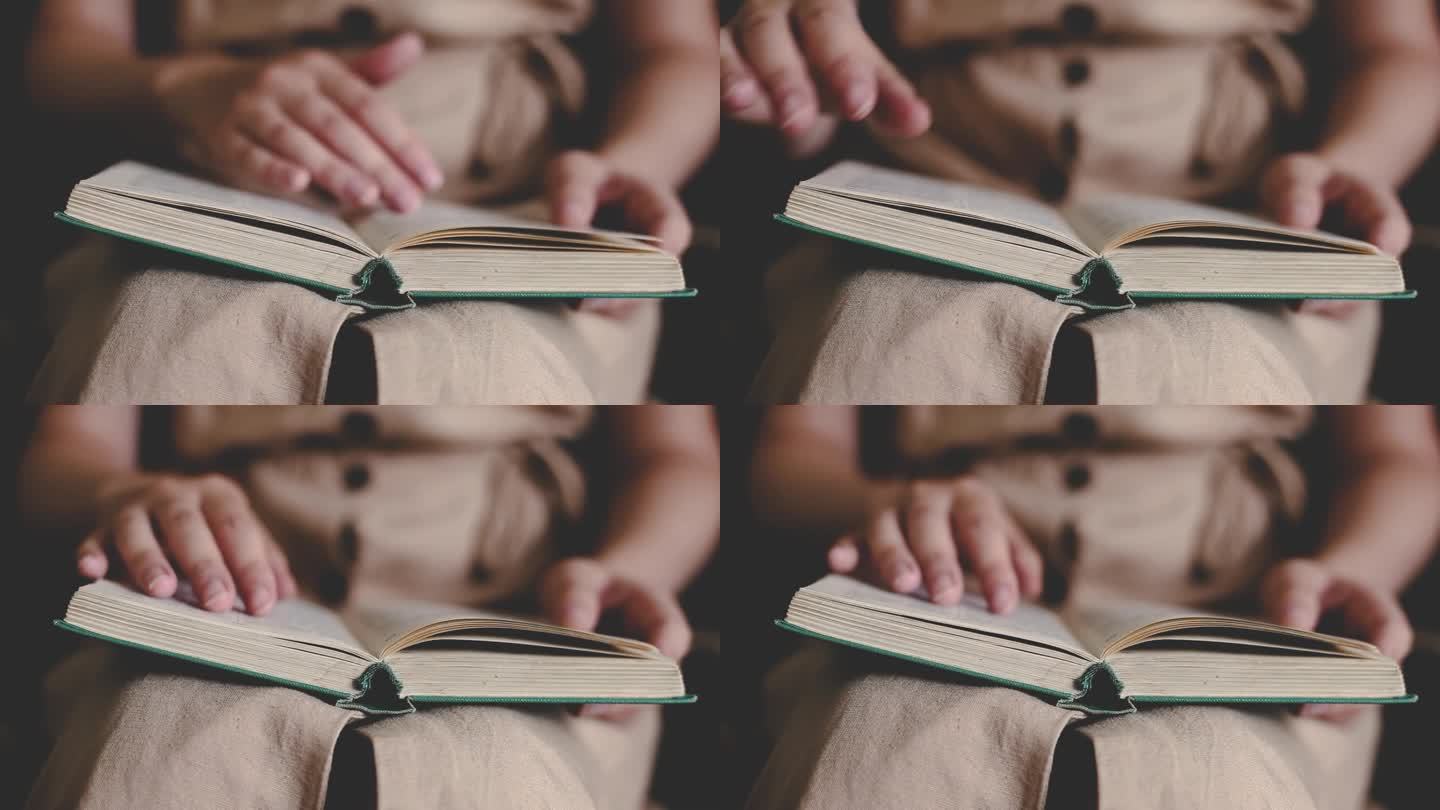 近距离观看翻页的女性双手。一位女士在读一本古书