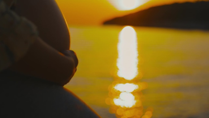 慢镜头:孕妇腹部触碰大海