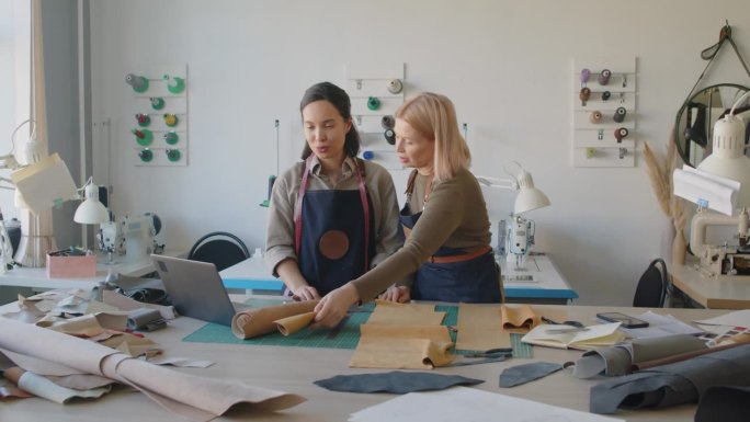 两个女裁缝在皮革工作室工作的新设计