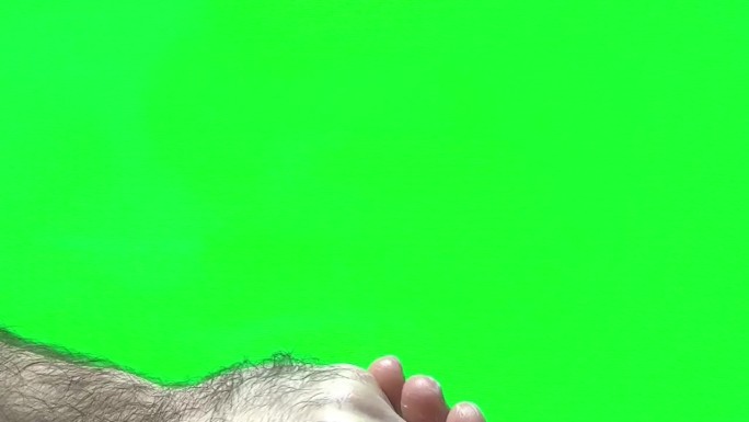 手护理绿色背景铬色男人在他的手上涂抹白色奶油多毛的男性的手在屏幕右侧的空间为文字和视频照片