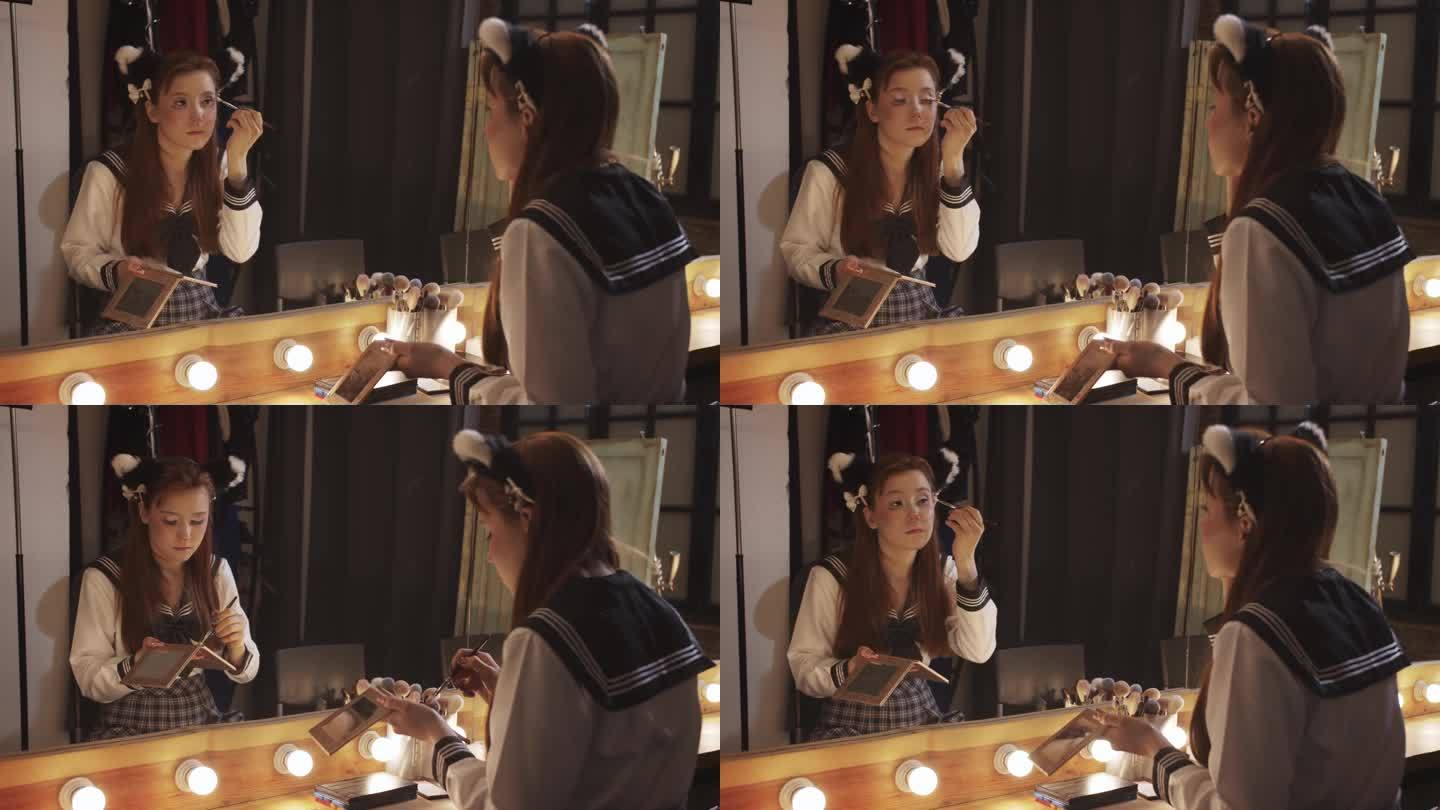 一个可爱的动漫女孩在后台化妆，看着大镜子