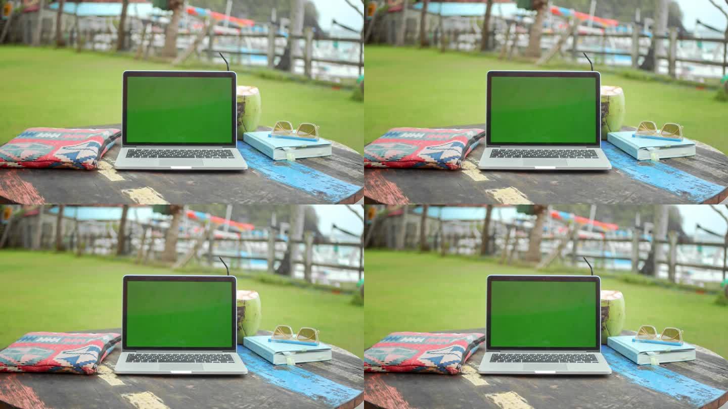 色度键笔记本显示器。绿屏电脑macbook。热带的背景。