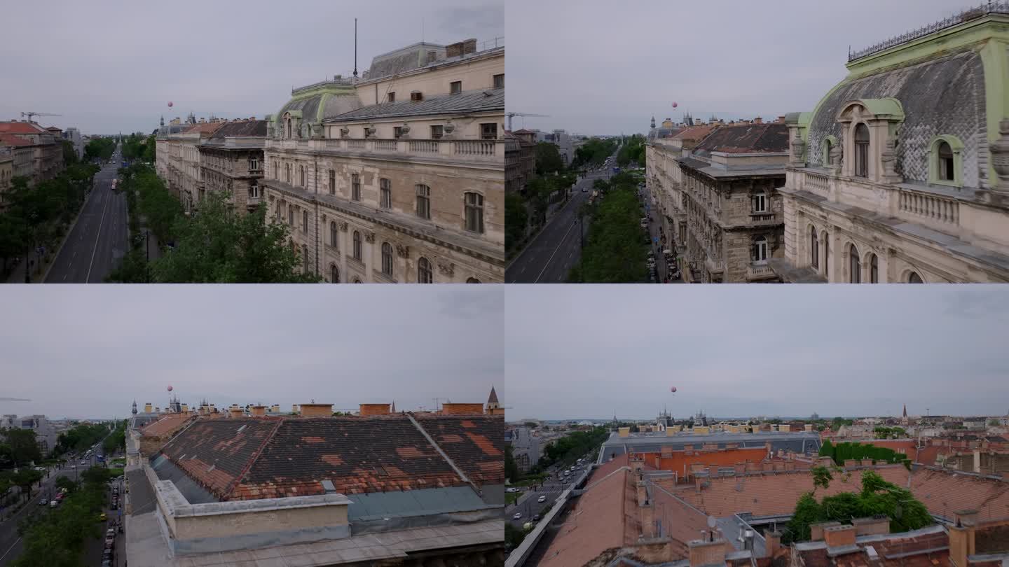 飞机飞过市中心旧多层公寓的屋顶。远处飘着红白相间的条纹气球。匈牙利布达佩斯
