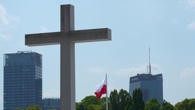 迎风飘扬的波兰国旗，对着华沙摩天大楼的天际线和教皇十字架——观光