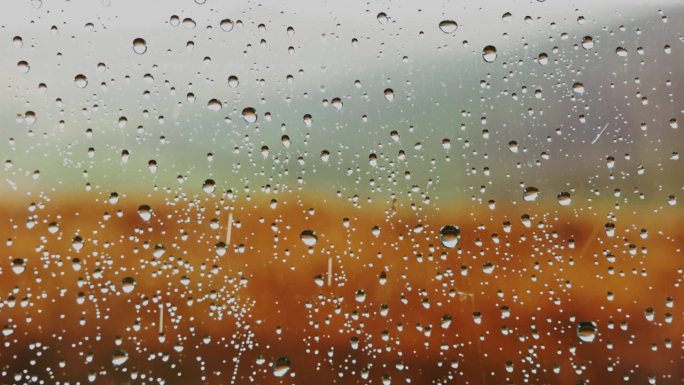 雨点溅落在窗户上窗外雨滴雨滴特写窗户