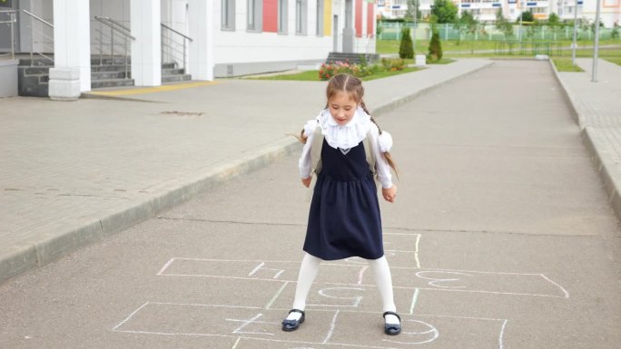初中女生在校园里玩跳房子游戏