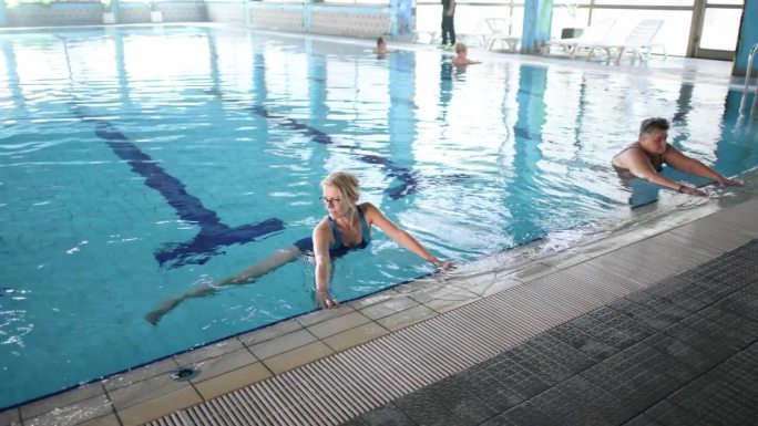 男女老年人在游泳池进行水中有氧运动