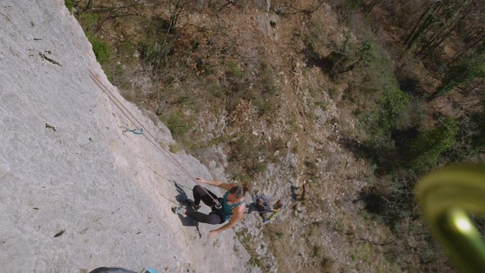 特写:女攀登者在攀爬岩壁时因抓不住而摔倒