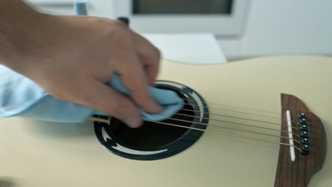 男子清洗甲板上的白色原声吉他。吉他服务理念。4k视频片段UHD 3840x2160