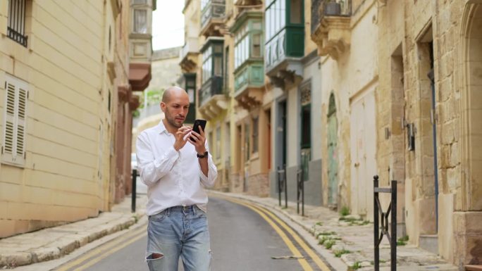 在马耳他的Cospicua，年轻的男游客正在用智能手机查找路线