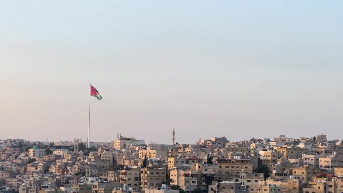 从安曼城上方的安曼城堡与约旦国旗美丽的城市天际线在白天4K