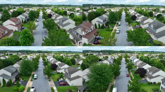 夏天的美国社区。航拍小车向前拍摄在社区的房屋和家庭。成熟的绿树。