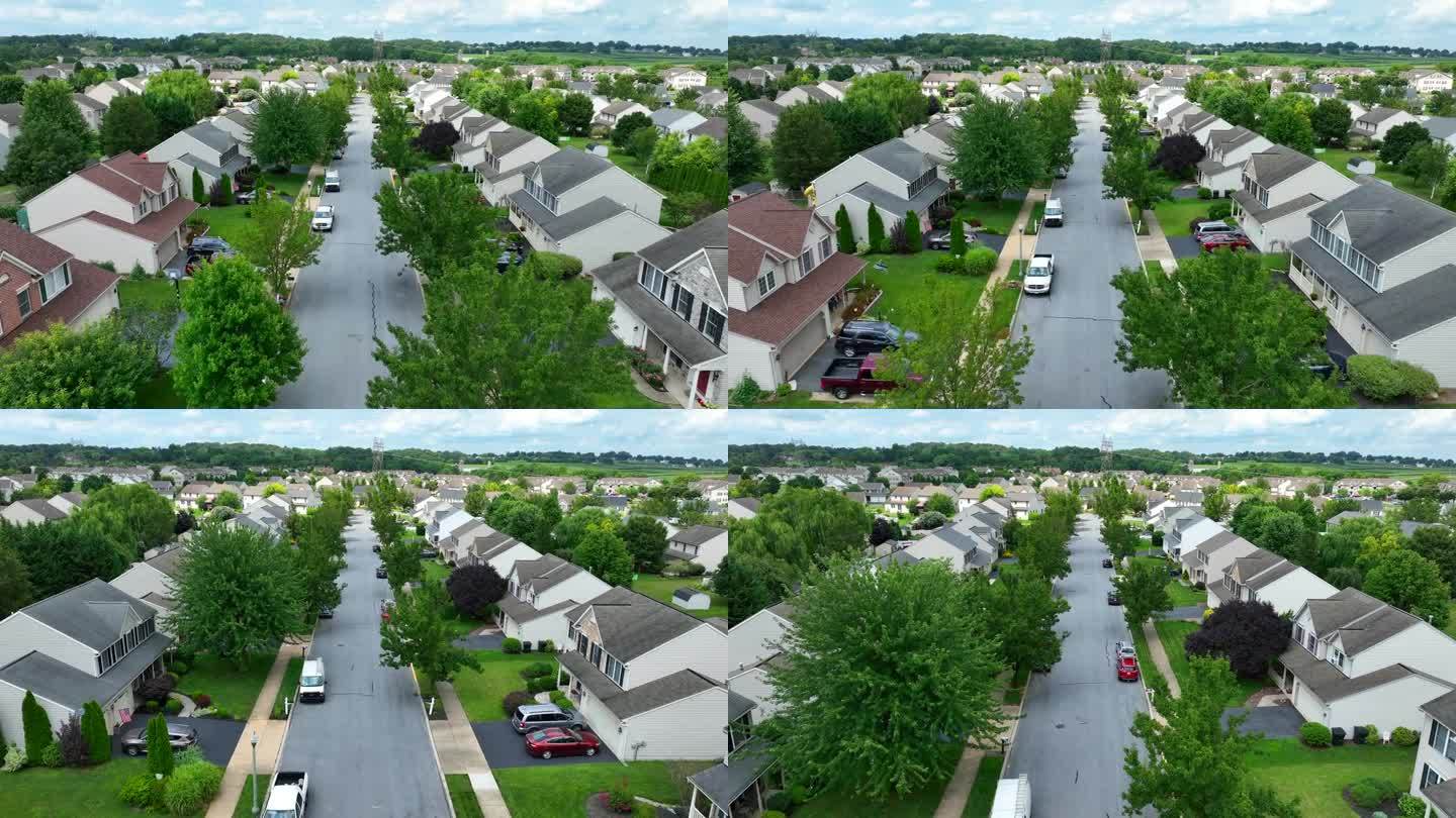 夏天的美国社区。航拍小车向前拍摄在社区的房屋和家庭。成熟的绿树。