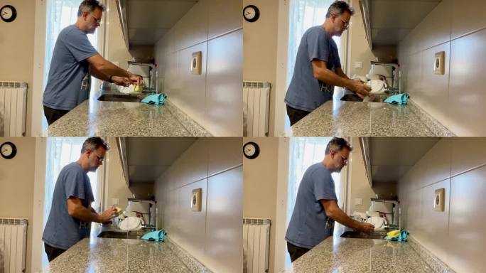 一个成熟的男人用家用化学品洗盘子和玻璃杯。分担家务的概念