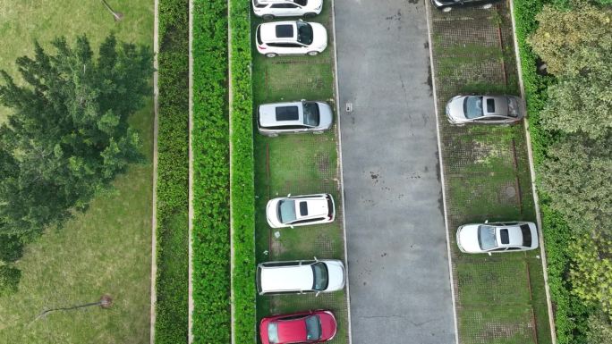 无人机飞过停在室外停车场的汽车的航拍画面，中国