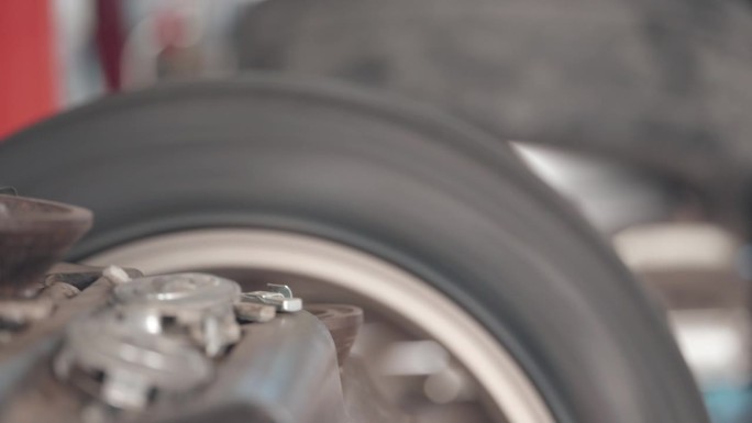 技师或机械师在修理汽车方面具有专业知识和技能，在车库里给合金车轮装上新轮胎后，使用特殊的机器来测试旋