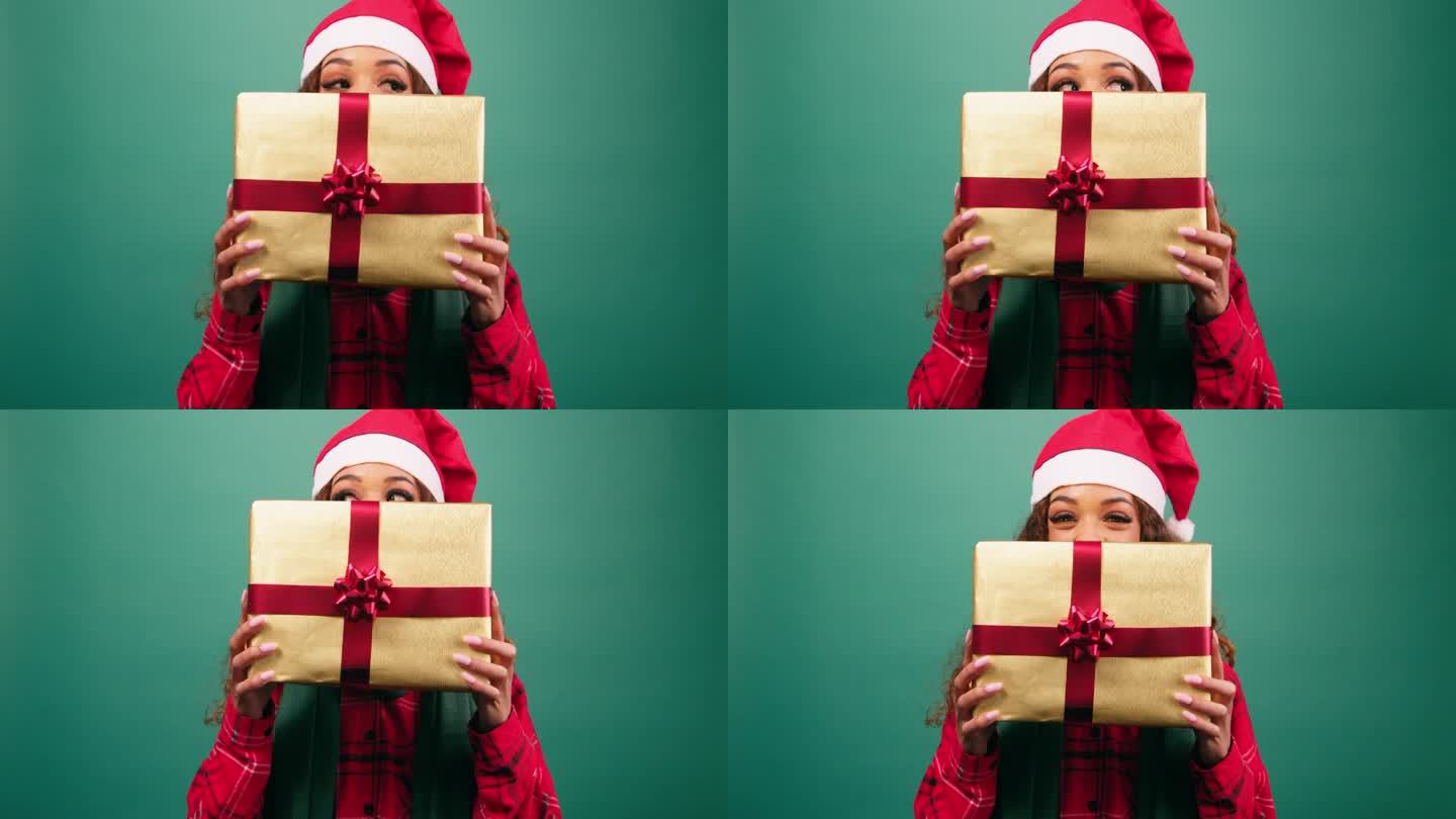年轻女子躲在圣诞礼物后面，露出眼睛，录影棚